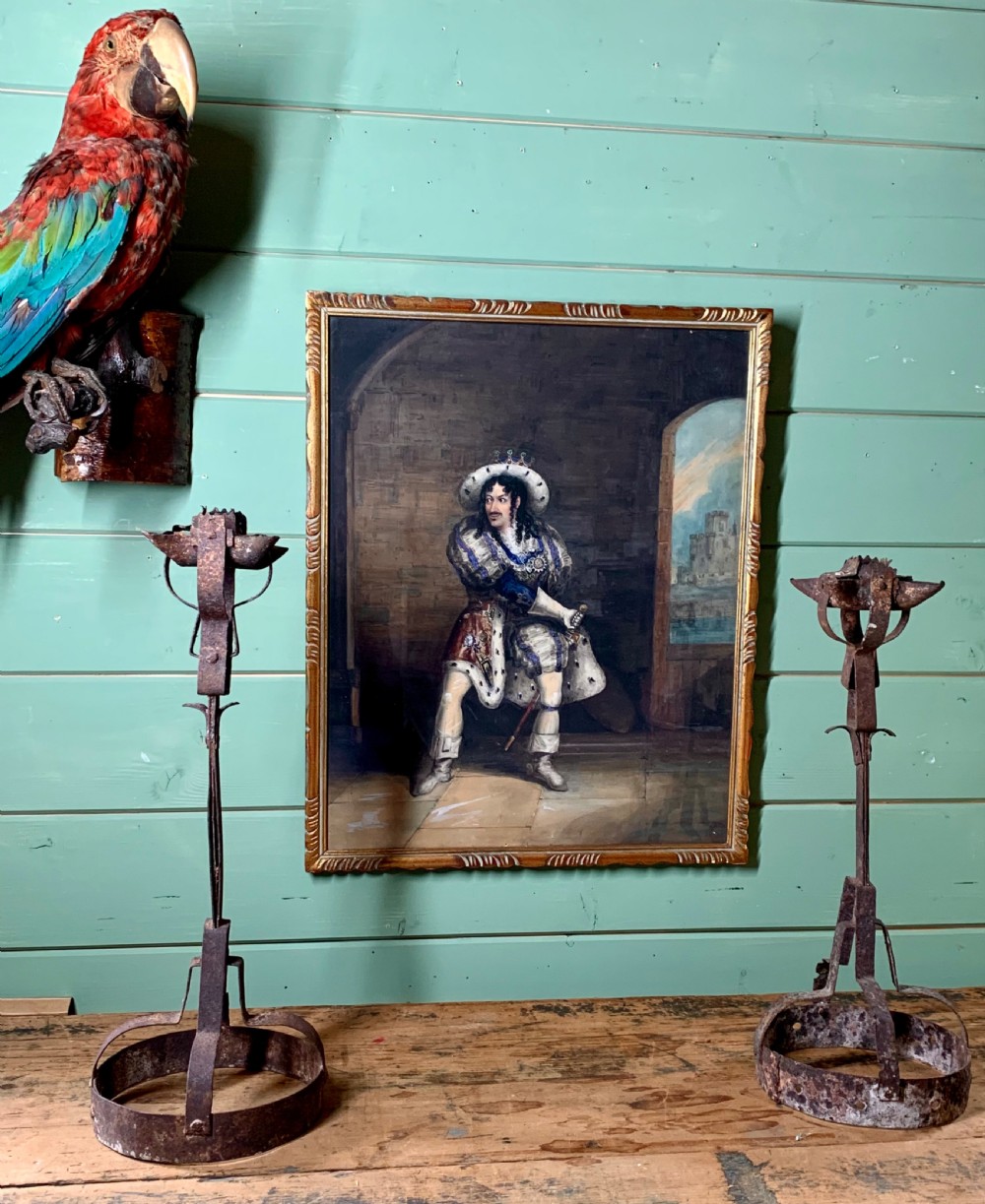 A framed watercolour portrait depicting a male figure in historical cavalier costume within a stone interior, encased in a gold moulded frame. View X