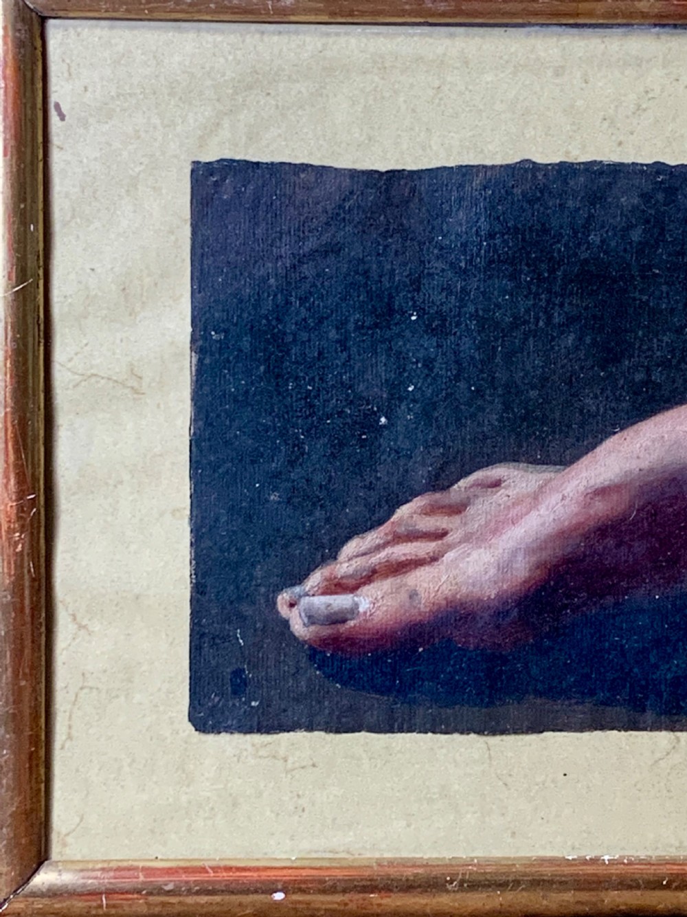 An early 19th-century academic oil study depicting a human foot rendered on paper, presented within a slender gilded wooden frame. View V