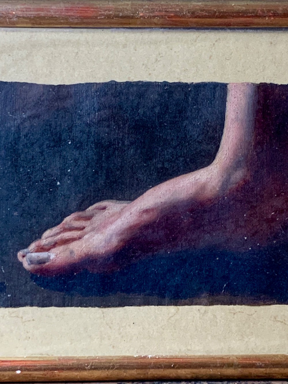 An early 19th-century academic oil study depicting a human foot rendered on paper, presented within a slender gilded wooden frame. View VI