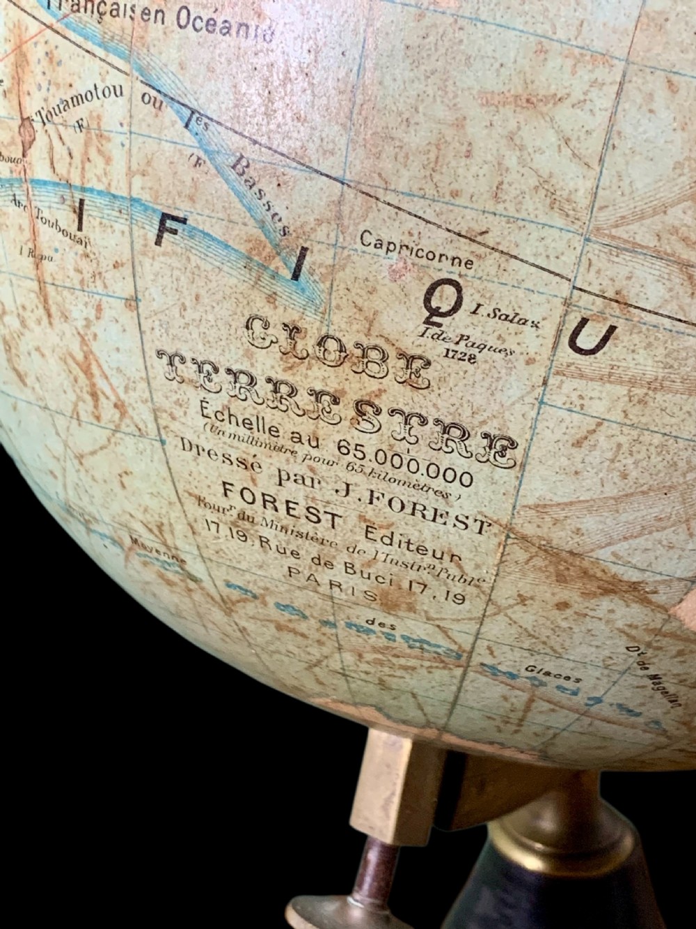 A vintage French terrestrial globe featuring cream paper map gores on a brass meridian half-ring and a turned dark wood pedestal base. View IV