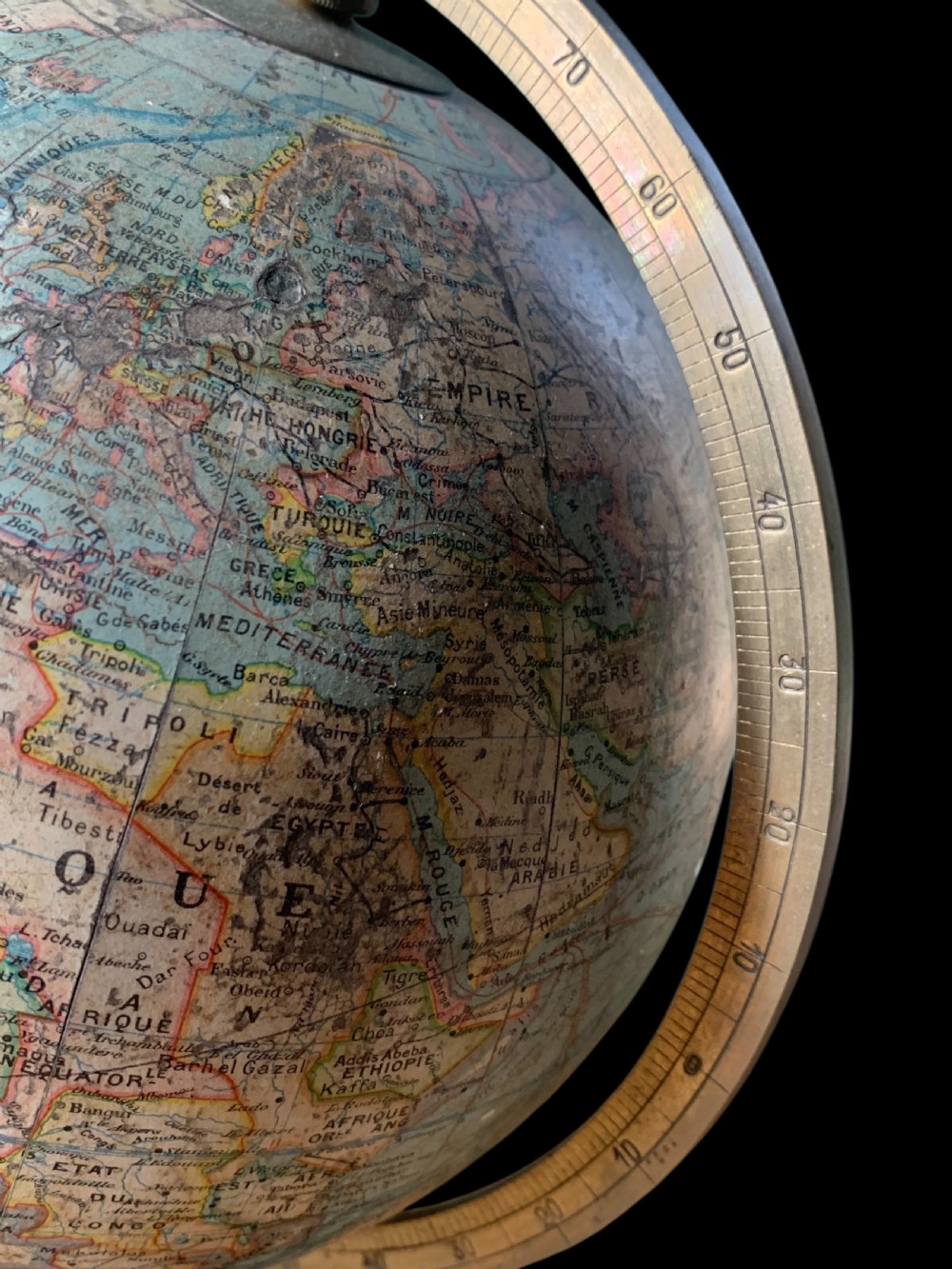 A vintage French terrestrial globe featuring cream paper map gores on a brass meridian half-ring and a turned dark wood pedestal base. View VII