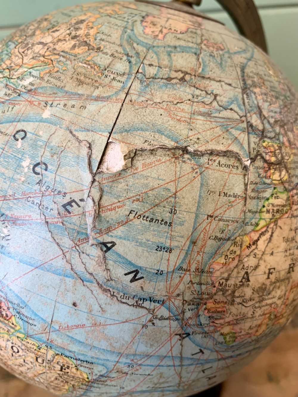 A vintage French terrestrial globe featuring cream paper map gores on a brass meridian half-ring and a turned dark wood pedestal base. View IX