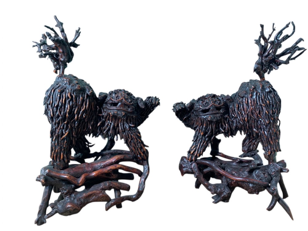 A pair of dark carved root wood Chinese guardian lion sculptures raised on organic natural root bases. View III