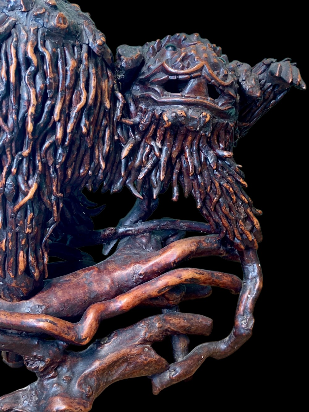 A pair of dark carved root wood Chinese guardian lion sculptures raised on organic natural root bases. View VII