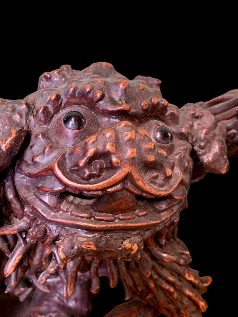 A pair of dark carved root wood Chinese guardian lion sculptures raised on organic natural root bases. View VIII