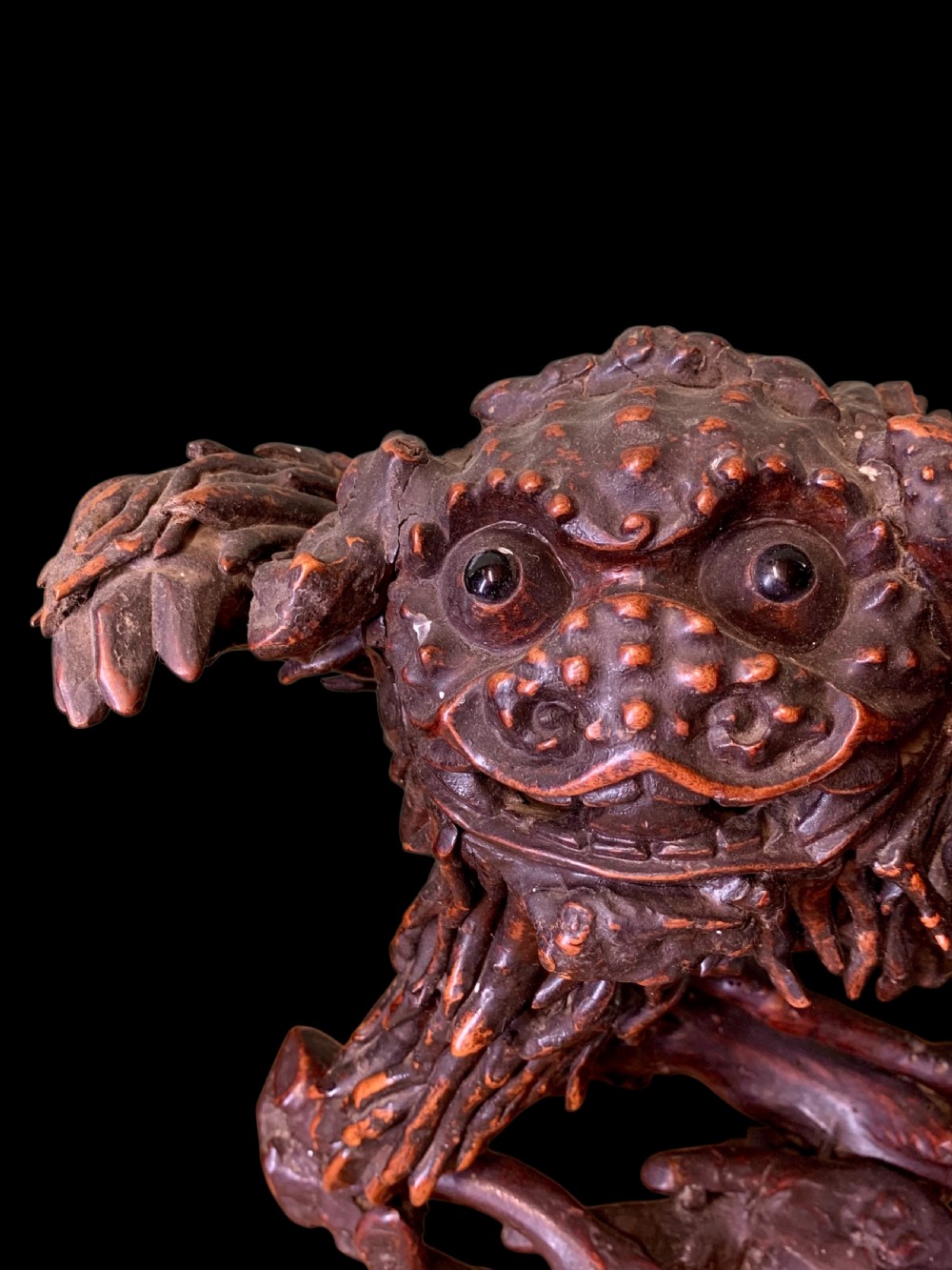 A pair of dark carved root wood Chinese guardian lion sculptures raised on organic natural root bases. View X
