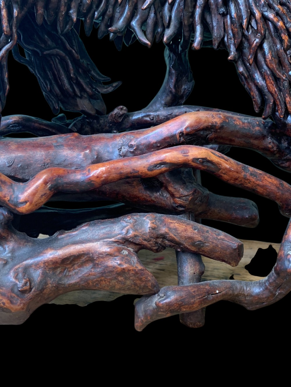 A pair of dark carved root wood Chinese guardian lion sculptures raised on organic natural root bases. View XII