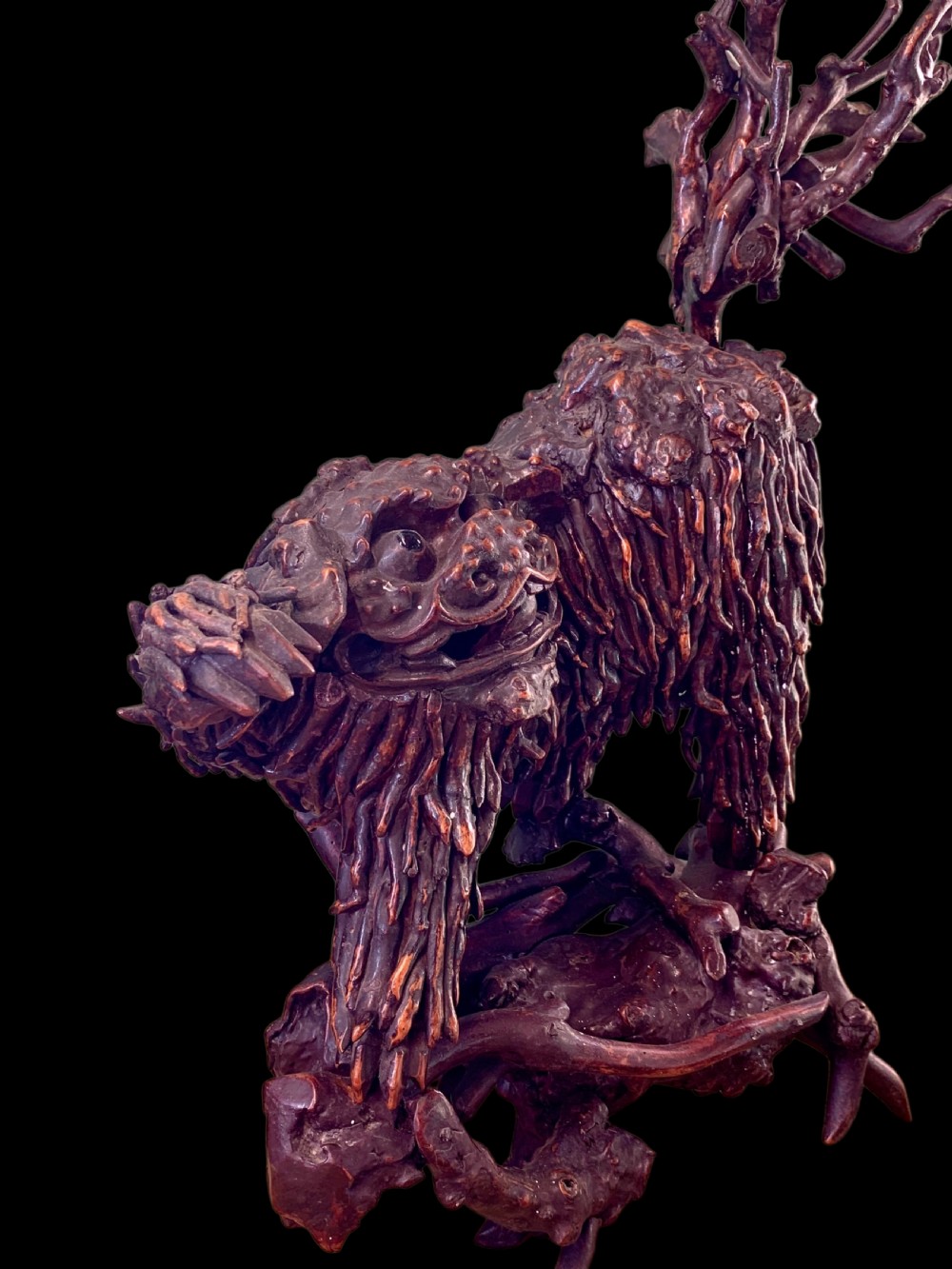 A pair of dark carved root wood Chinese guardian lion sculptures raised on organic natural root bases. View XIII