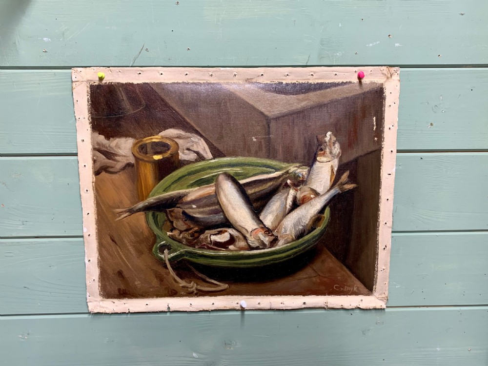 An unframed early 20th-century oil painting on canvas depicting a green ceramic basin filled with fish alongside a brass vessel on a wooden surface.