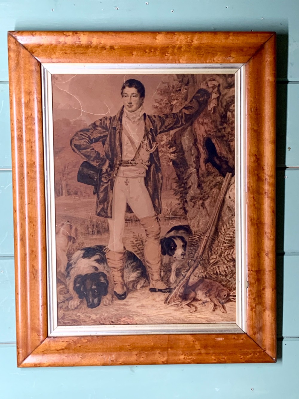 A framed Georgian watercolour portrait depicting a standing hunter in period attire alongside his hounds within a natural woodland landscape.