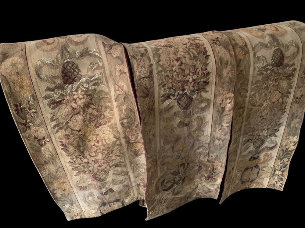 Three vertical woven French tapestry panels displaying floral garlands, urns, and foliate scrollwork in neutral beige, rose, and green tones.