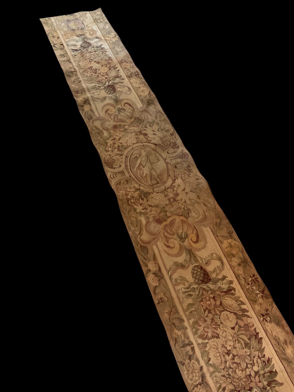 Three vertical woven French tapestry panels displaying floral garlands, urns, and foliate scrollwork in neutral beige, rose, and green tones. View III