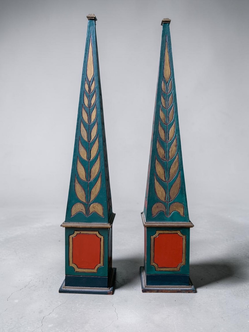 A DECORATIVE PAIR OF ANTIQUE POLYCHROME PAINTED OBELISKS