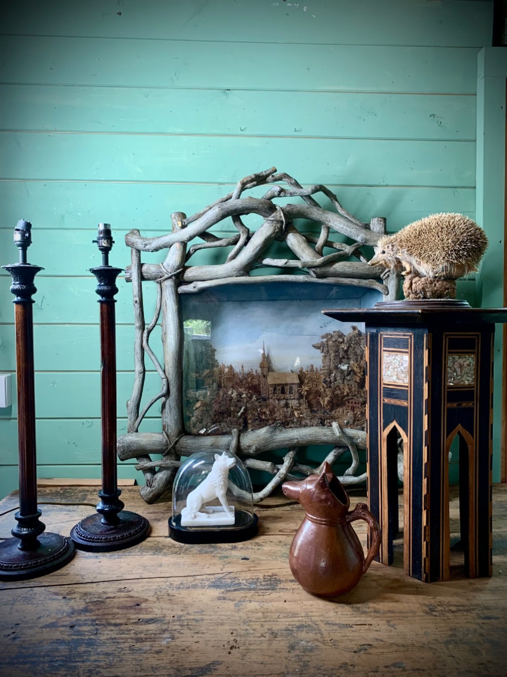 An antique three-dimensional cork diorama depicting a village church scene enclosed within a frame crafted from intertwined rustic twigs. View III