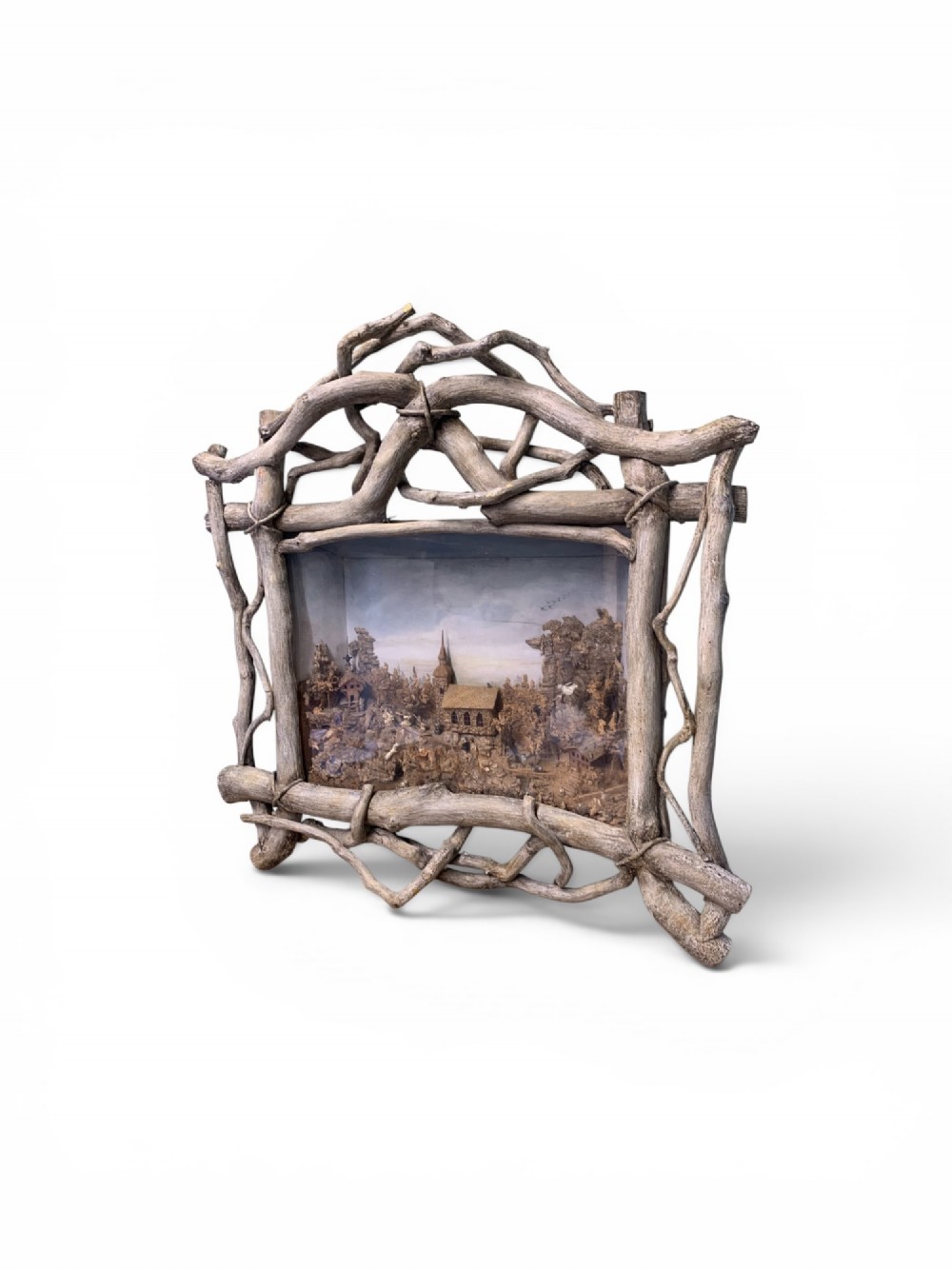 An antique three-dimensional cork diorama depicting a village church scene enclosed within a frame crafted from intertwined rustic twigs. View IV