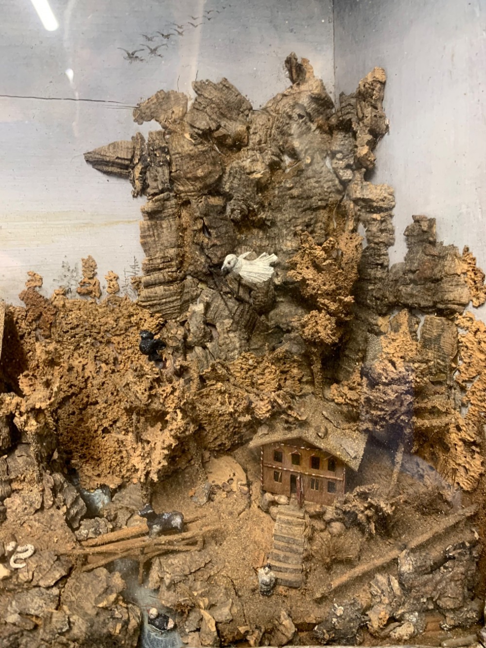 An antique three-dimensional cork diorama depicting a village church scene enclosed within a frame crafted from intertwined rustic twigs. View VIII
