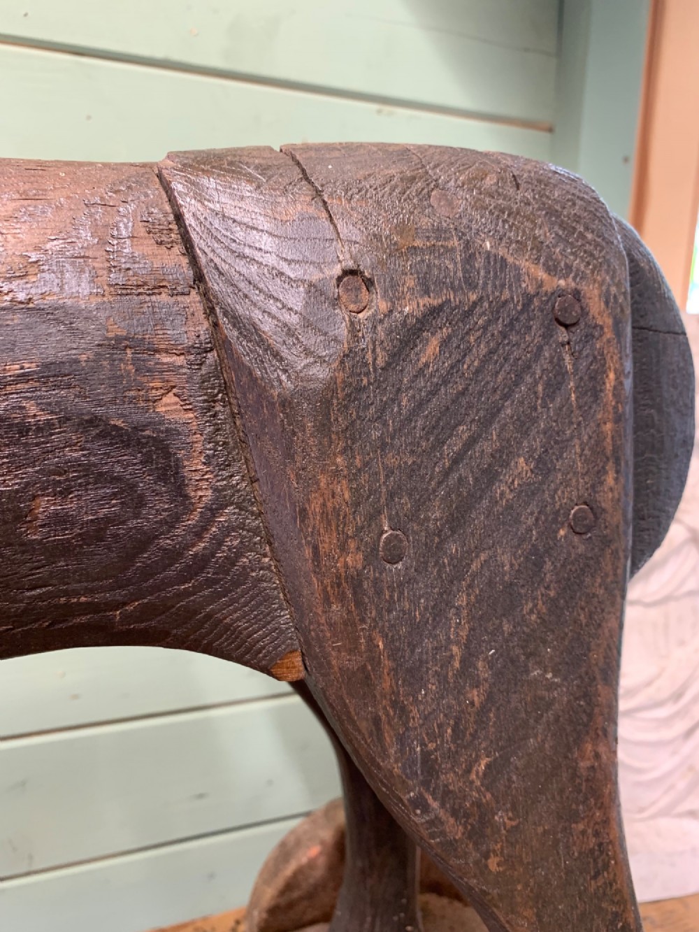 A naive hand-carved dark wood figure of a horse mounted on a flat wooden base with four simple circular wheels. View VIII