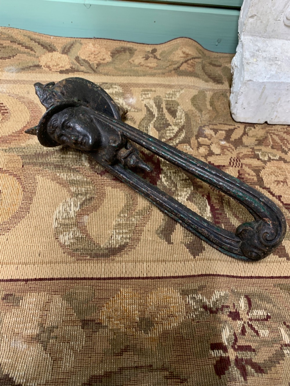 A Victorian cast iron door knocker featuring a sculpted classical Hermes head atop a drop-down loop striker. View IX