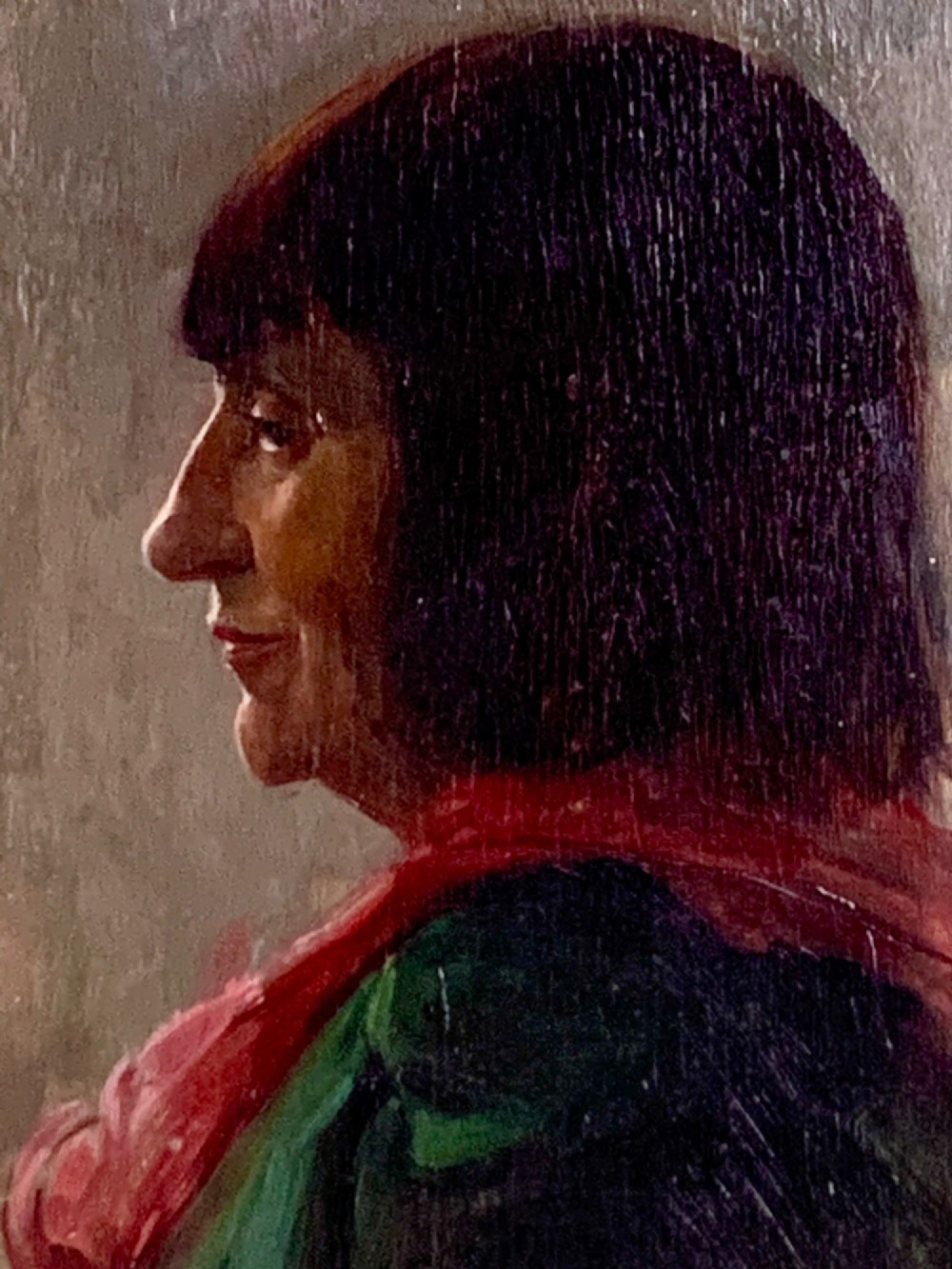 A side profile oil portrait painting of a woman with dark bobbed hair wearing a red scarf against a muted grey background.