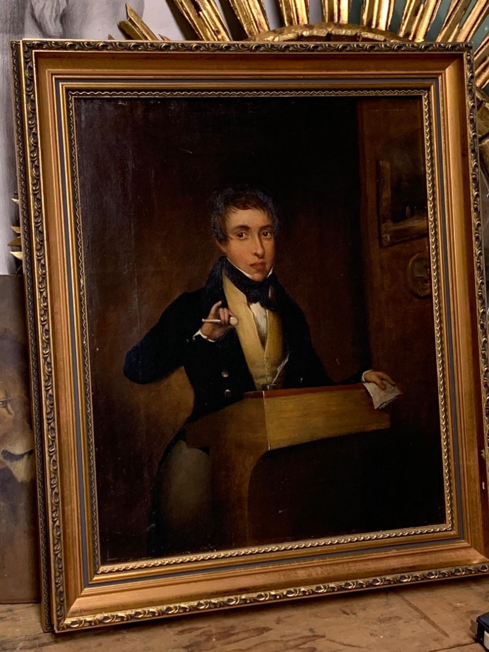 An early 19th-century oil portrait depicting a gentleman at a podium holding a small mallet, housed within a gold leaf frame. View II