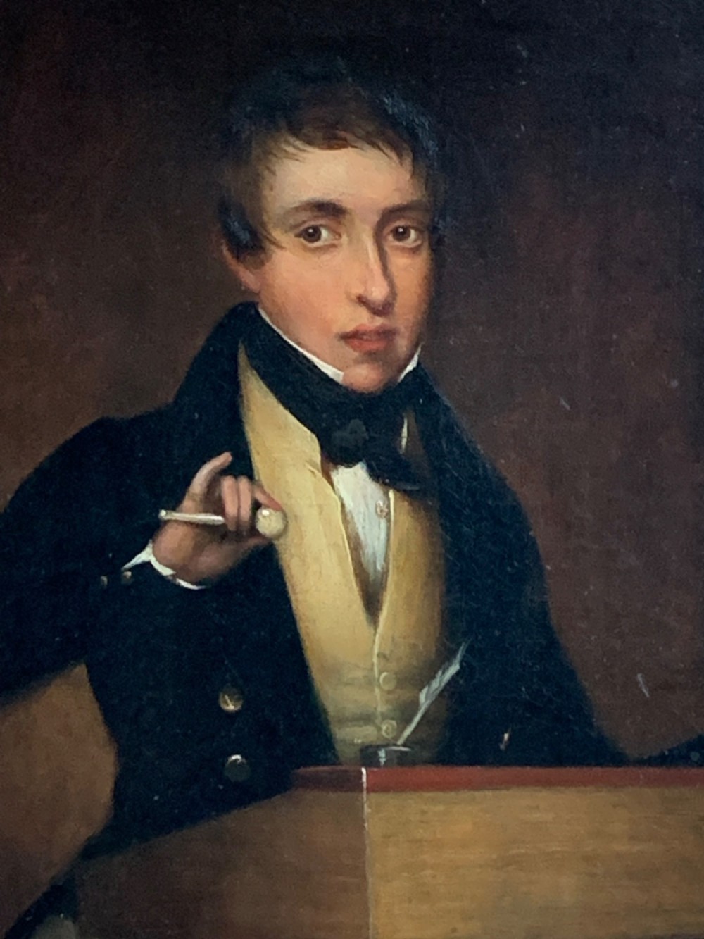 An early 19th-century oil portrait depicting a gentleman at a podium holding a small mallet, housed within a gold leaf frame. View IV