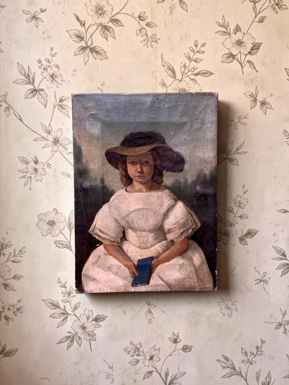An early 19th-century oil portrait depicting a young girl in a white puff-sleeved dress and bonnet holding a book. View II