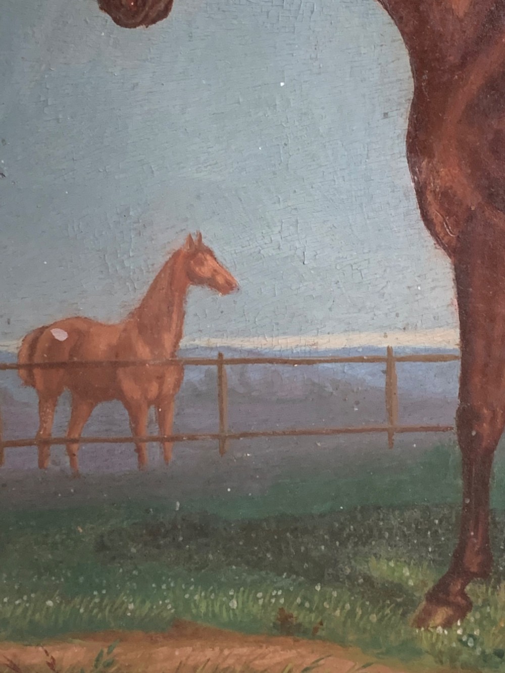 An antique oil painting on wood panel depicting a brown horse standing in a grassy landscape under a blue sky, set within a black ebonised frame with a gilt inner border. View V