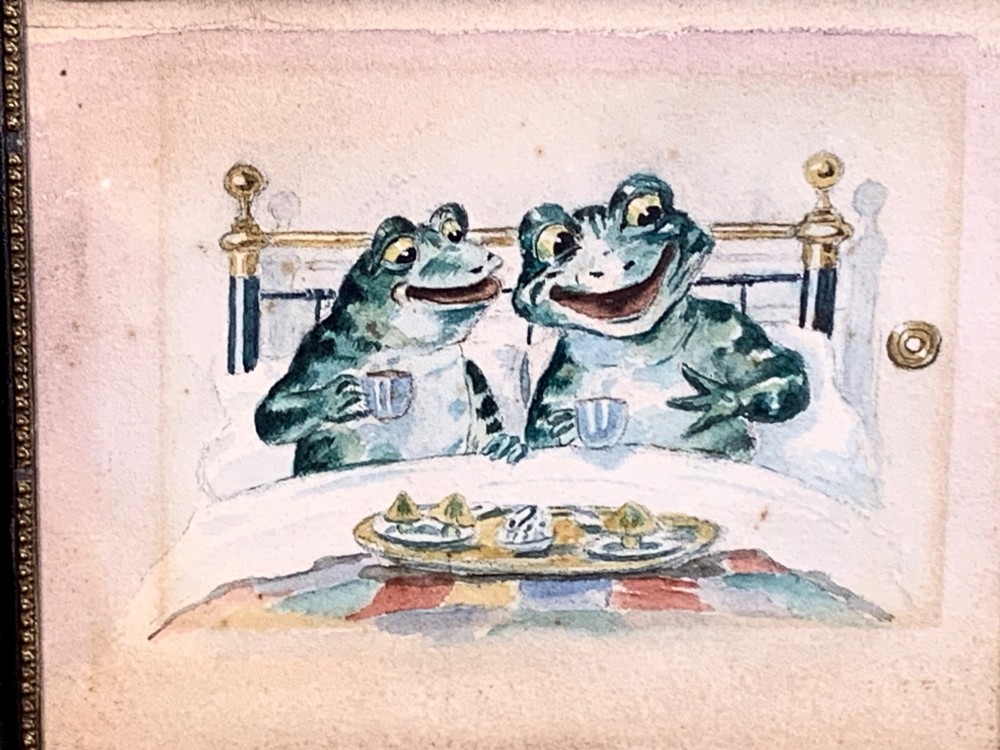 A framed Victorian watercolour painting depicting two anthropomorphic green frogs sitting in a brass bed and drinking tea. View II