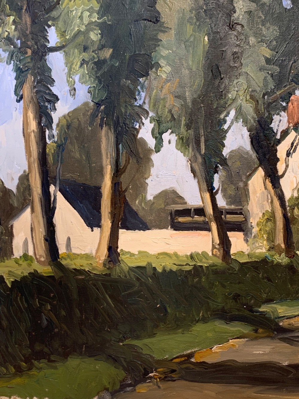 An early twentieth-century French oil painting depicting a sunlit country lane leading past tall trees towards a white farmhouse with terracotta chimneys under a light blue sky. View V