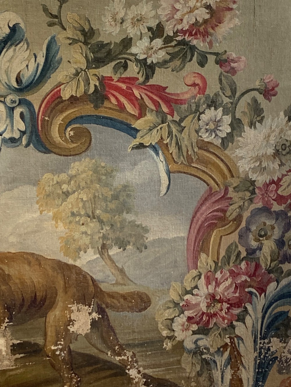 An early 19th-century oil painting on canvas featuring a brown dog framed by a floral cartouche against a muted sage green background. View IV