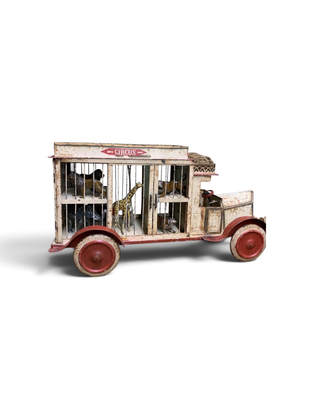A 1920s painted tinplate Kibri circus lorry featuring cream side cage bars, red wheels, red accents, and miniature animal figures enclosed inside.