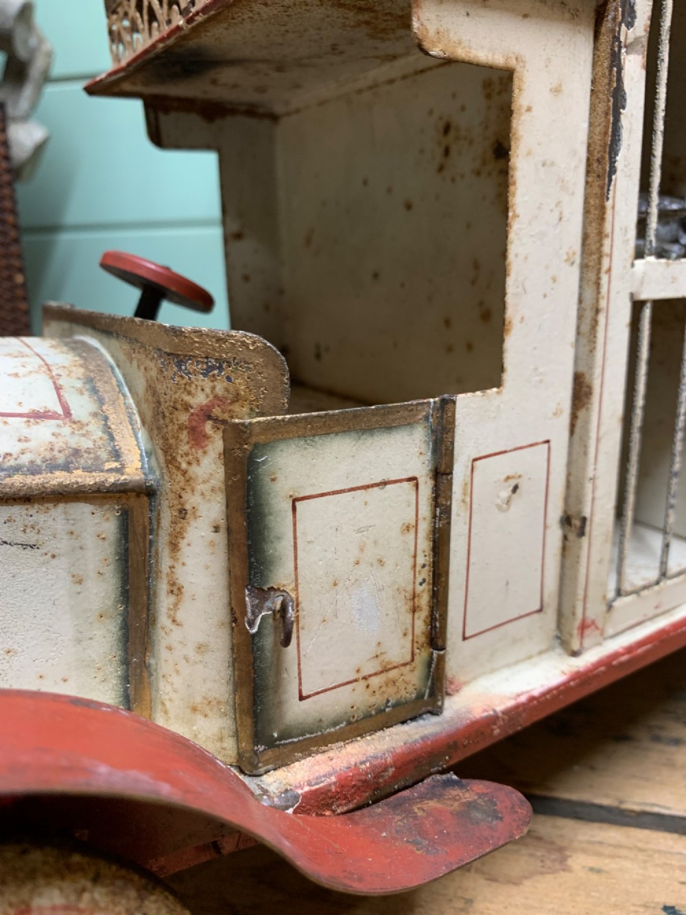 A 1920s painted tinplate Kibri circus lorry featuring cream side cage bars, red wheels, red accents, and miniature animal figures enclosed inside. View VI