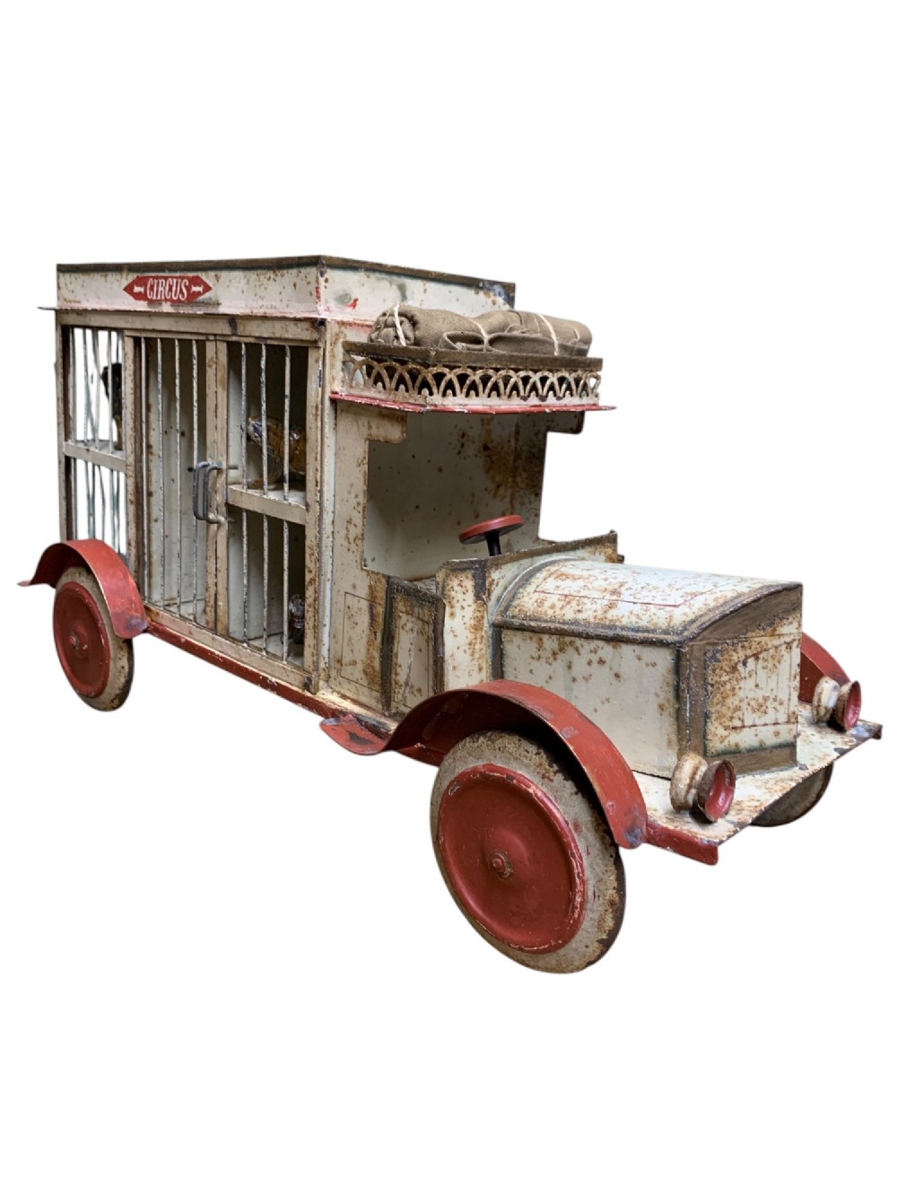 A 1920s painted tinplate Kibri circus lorry featuring cream side cage bars, red wheels, red accents, and miniature animal figures enclosed inside. View VII