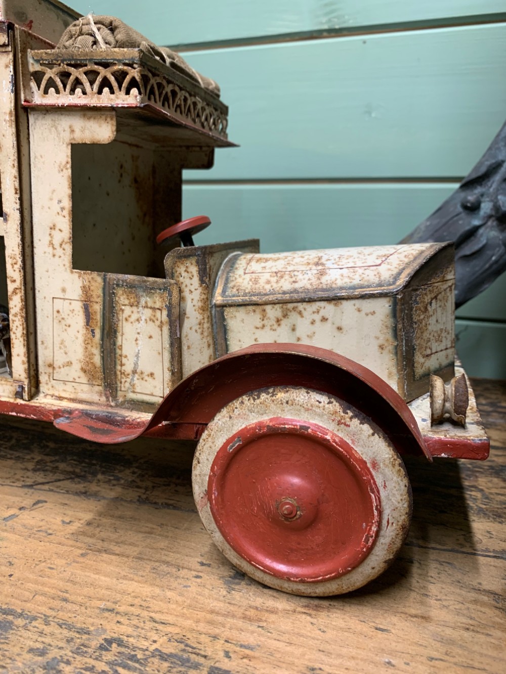 A 1920s painted tinplate Kibri circus lorry featuring cream side cage bars, red wheels, red accents, and miniature animal figures enclosed inside. View VIII