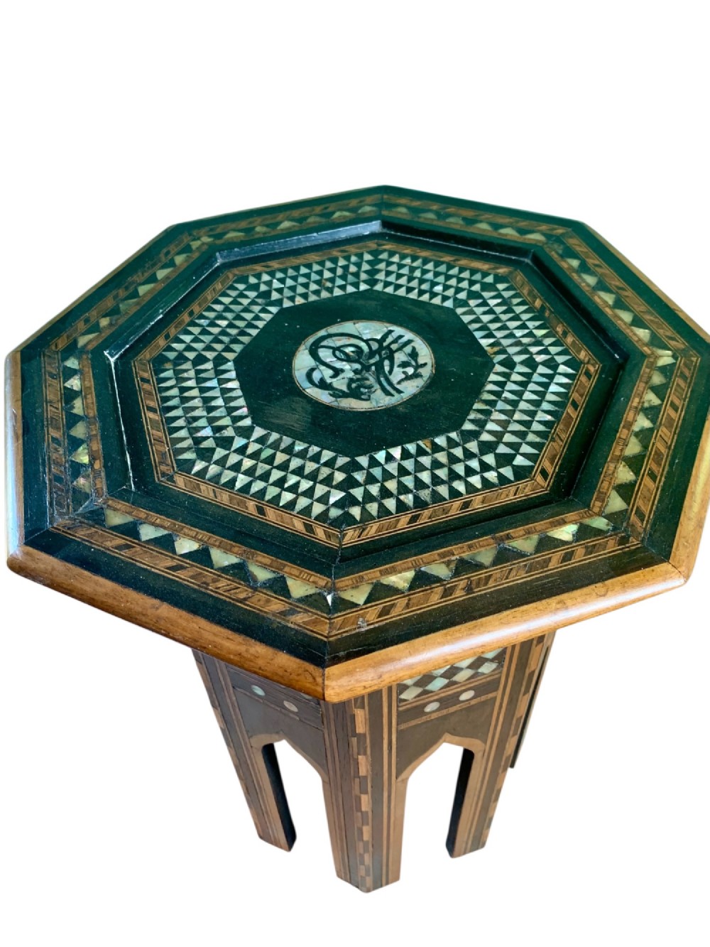 An early 20th-century octagonal Moorish side table made of dark wood with geometric mother-of-pearl inlay and pointed arch legs. View VI