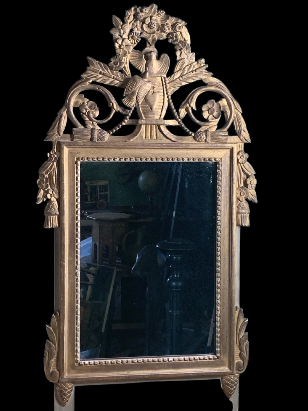 An 18th-century French giltwood marriage mirror with an ornate carved crest featuring doves, floral garlands, and a rectangular beaded mirror frame. View IV
