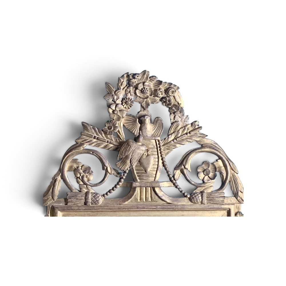 An 18th-century French giltwood marriage mirror with an ornate carved crest featuring doves, floral garlands, and a rectangular beaded mirror frame. View IX