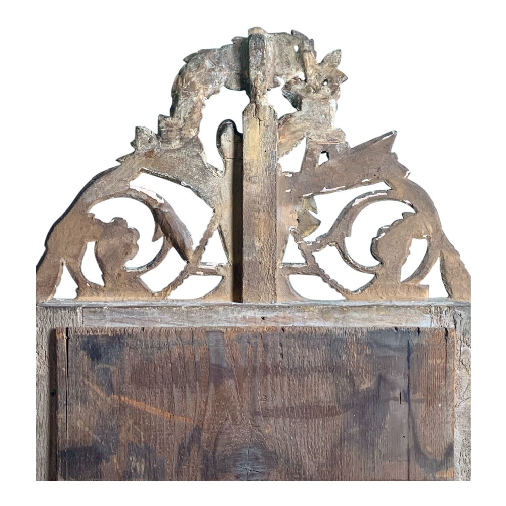 An 18th-century French giltwood marriage mirror with an ornate carved crest featuring doves, floral garlands, and a rectangular beaded mirror frame. View XI