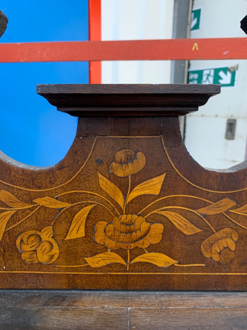 An 18th-century Dutch wall cabinet made of warm brown wood with botanical marquetry inlays, featuring a central glazed door, canted side panels, and a shaped pediment. View VIII