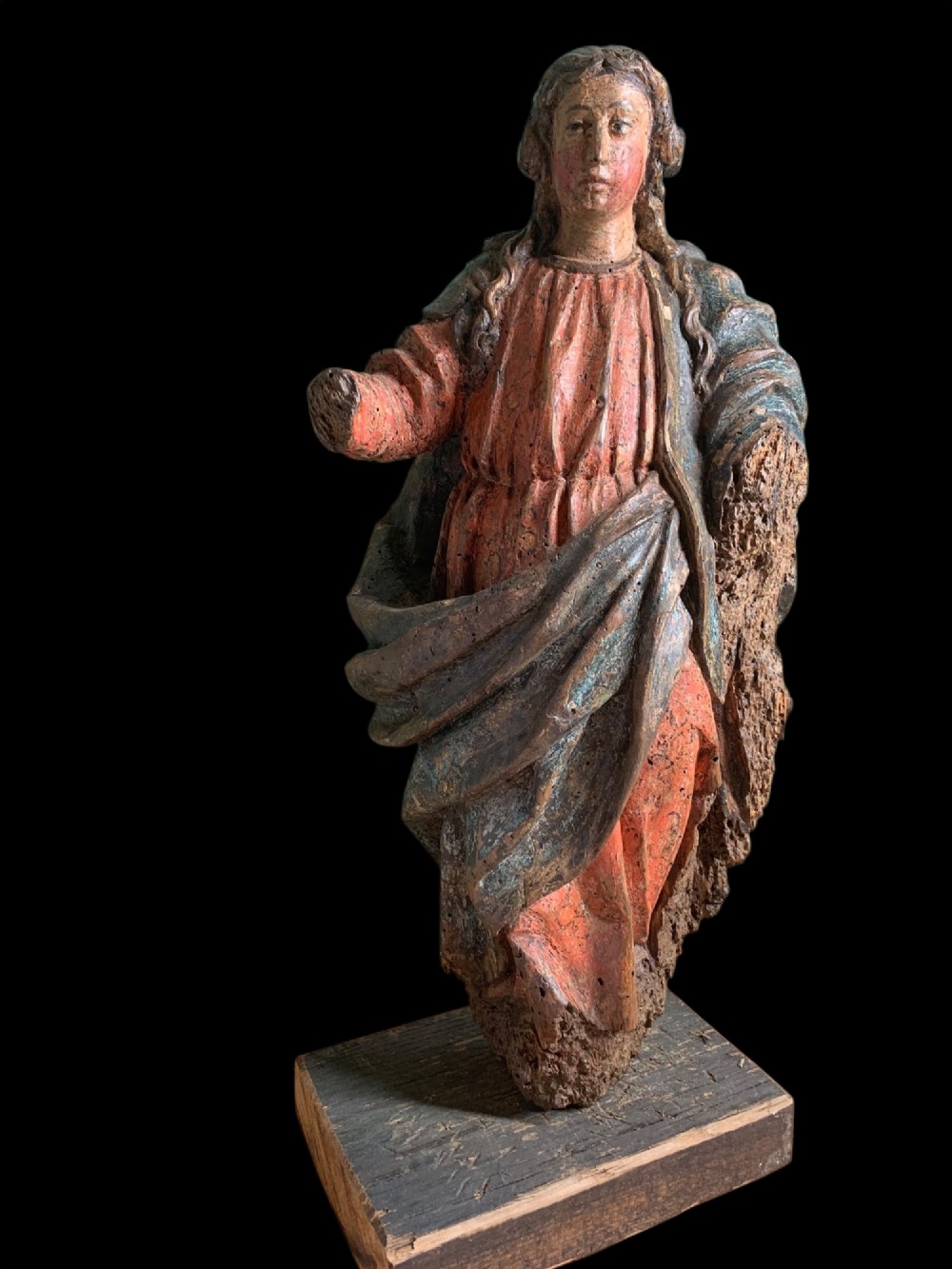 An eighteenth-century carved wood figure of a saint featuring red and blue polychrome paint, set upon a rectangular wooden base. View II