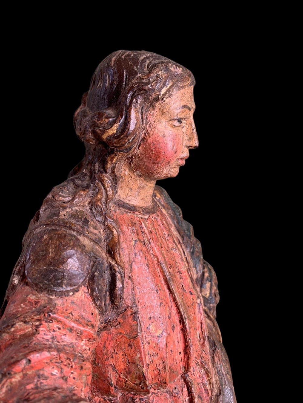 An eighteenth-century carved wood figure of a saint featuring red and blue polychrome paint, set upon a rectangular wooden base. View VII