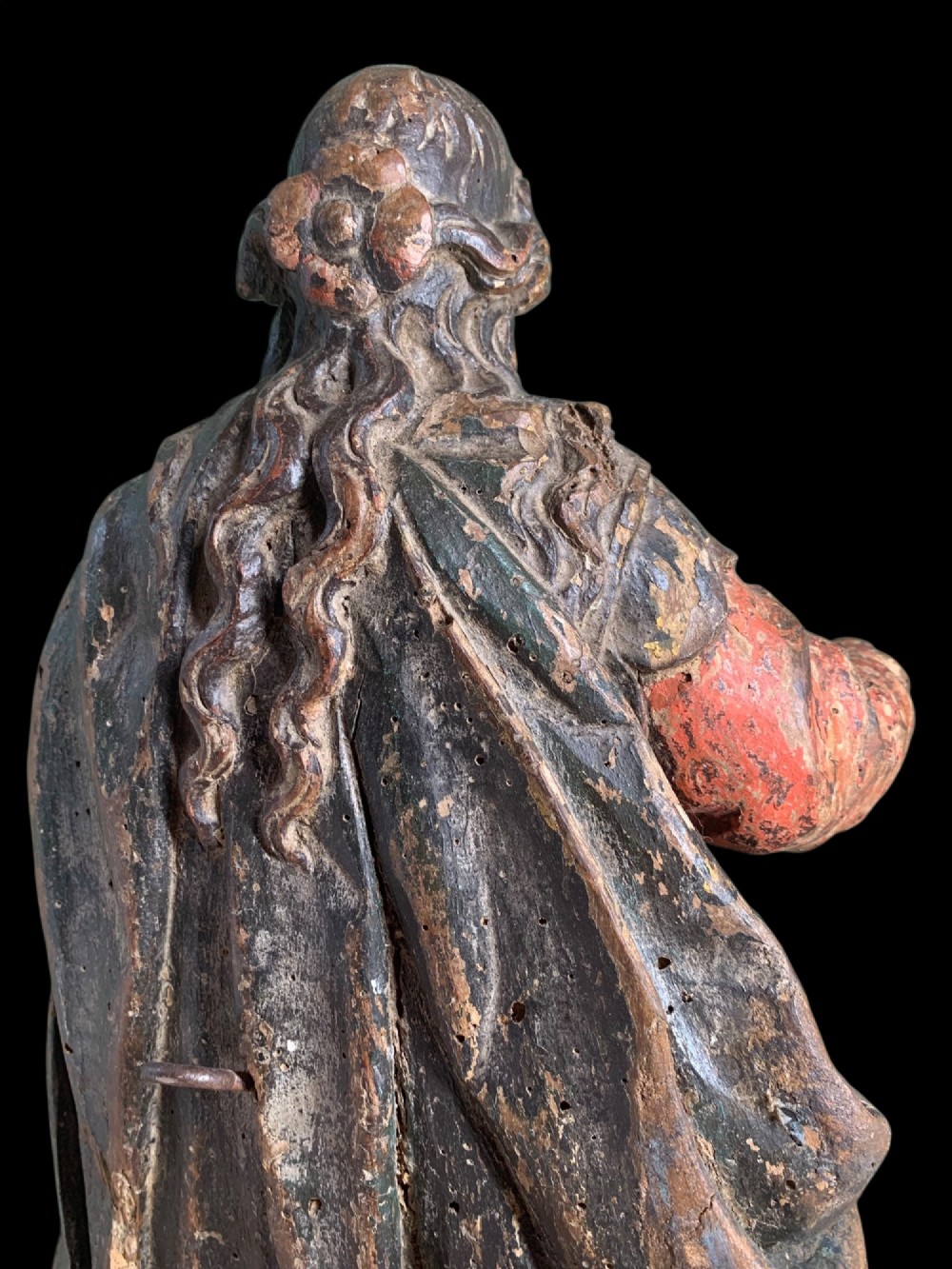 An eighteenth-century carved wood figure of a saint featuring red and blue polychrome paint, set upon a rectangular wooden base. View X