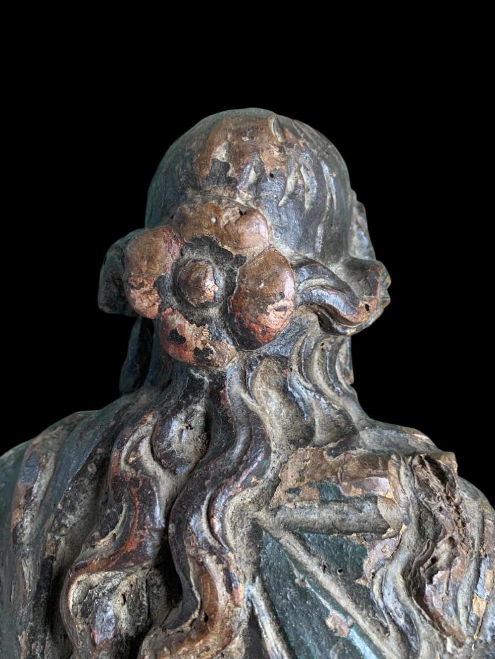 An eighteenth-century carved wood figure of a saint featuring red and blue polychrome paint, set upon a rectangular wooden base. View XI