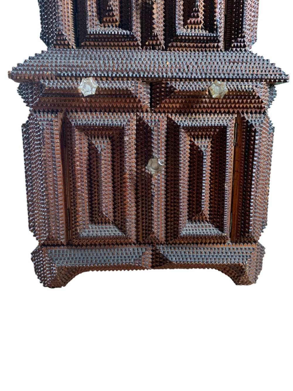 A miniature dark wood tramp art cabinet featuring layered notch-carved geometric borders, double upper doors, and small glass knobs. View III