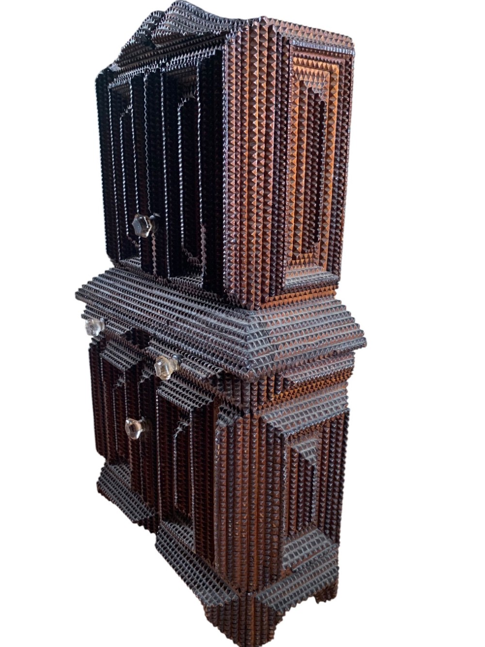 A miniature dark wood tramp art cabinet featuring layered notch-carved geometric borders, double upper doors, and small glass knobs. View IX