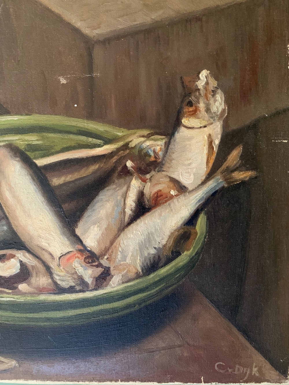 An unframed rectangular oil painting on canvas depicting a group of small fish arranged in a green glazed bowl on a wooden surface. View V