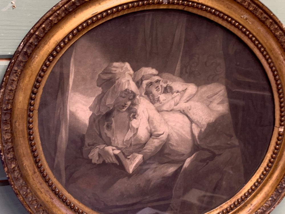 An oval 18th-century sepia print displaying a domestic bedroom scene, enclosed within a carved circular giltwood frame with beaded detailing. View III