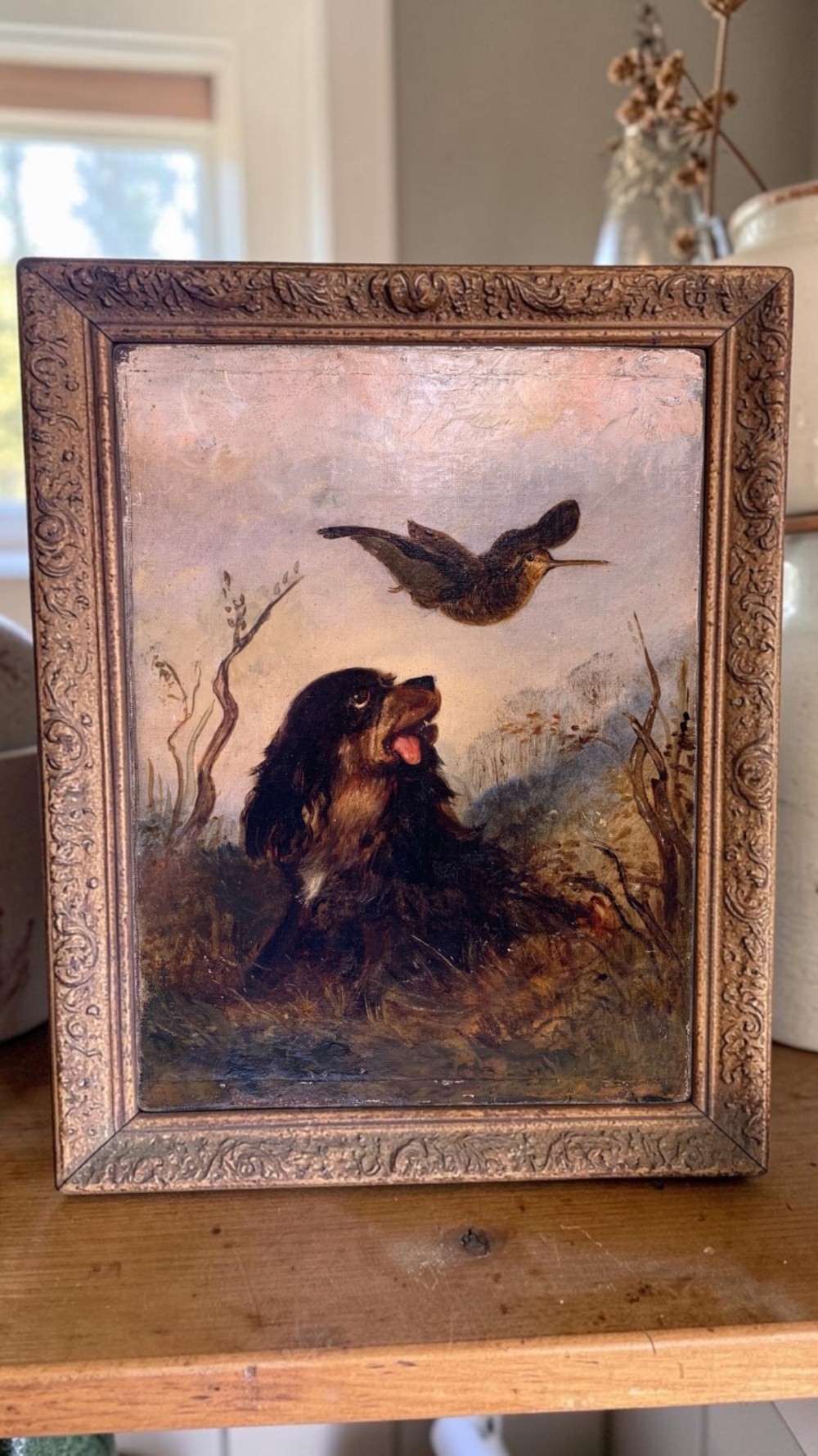 A 19th-century oil painting depicting a black and tan spaniel seated in a landscape looking upward at a woodcock bird in flight. View III