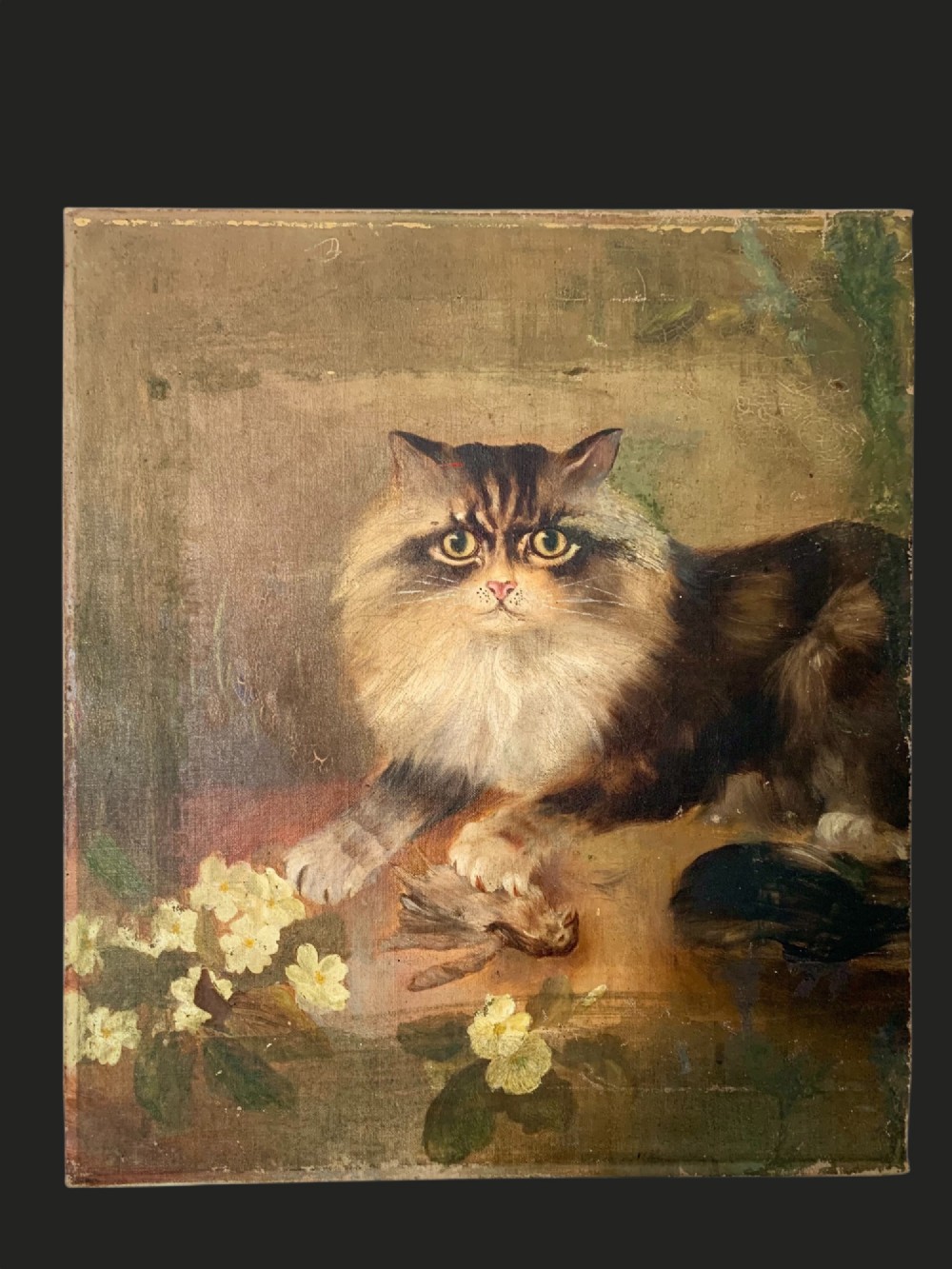 A 19th-century naive school oil painting depicting a fluffy longhaired cat holding a small bird, set beside pale cream flowers against a warm brown background.