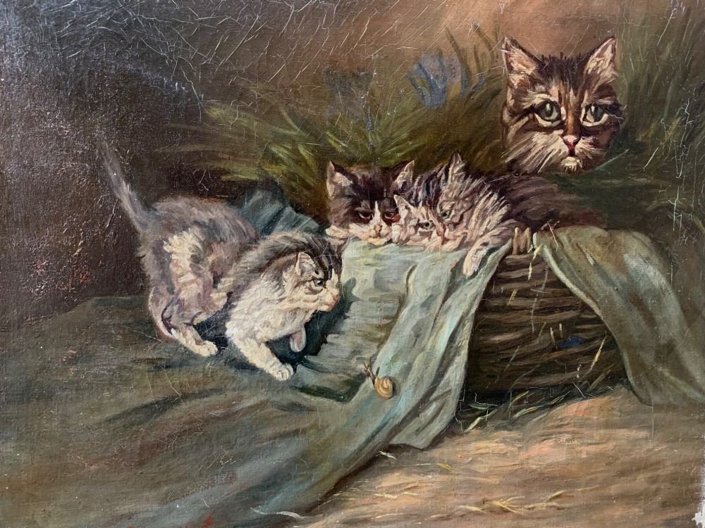 An antique oil painting depicting four kittens and a cat observing a small snail on a green cloth beside a woven basket.